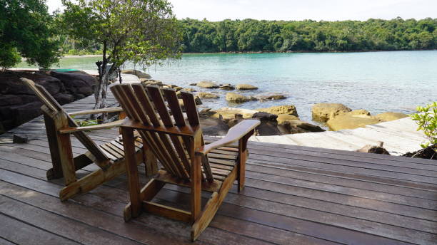 istock Adirondack Chairs On Floorboard Against Sea 991517308