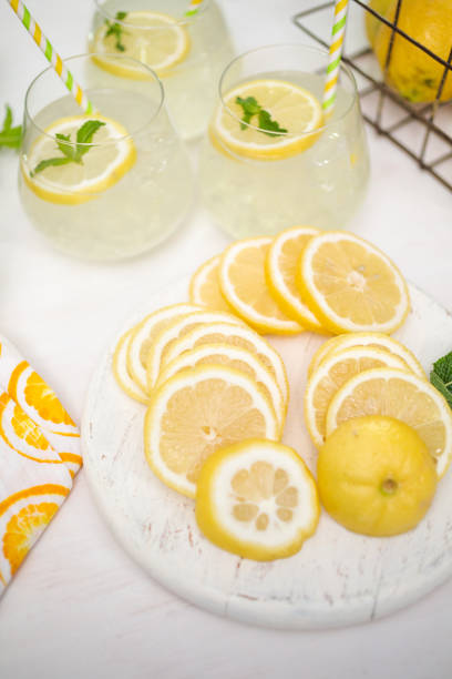istock Fresh sliced lemon on a white wood cutting board. 991563600