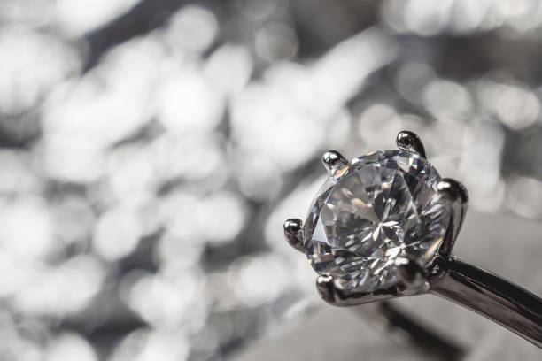 istock luxury engagement Diamond ring with abstract bokeh light background 991567896