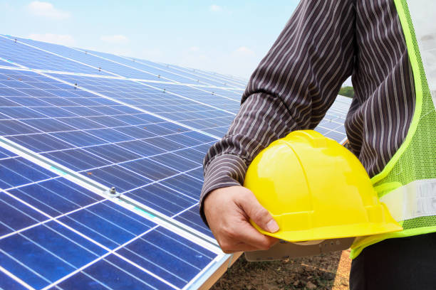 young business man engineer hold yellow helmet at solar panel power plant construction site background - solar power station solar panel energy electrician imagens e fotografias de stock