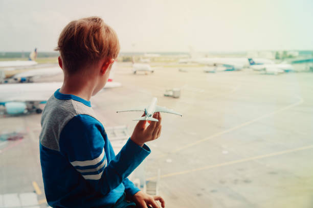 istock boy playing with toy plane while waiting in airport 991600452