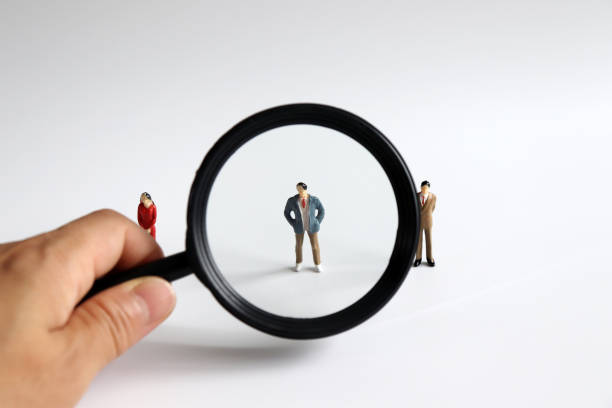 istock Magnifier and miniature people. 991603472