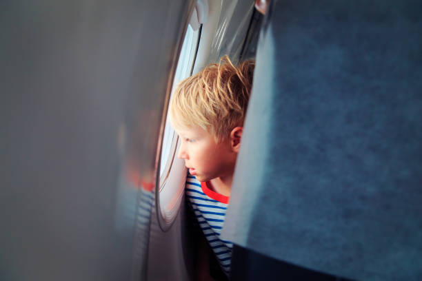 istock little boy travel by plane looking through window 991603646
