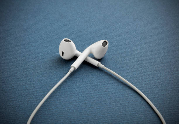 istock Modern white earphones with on blue background 991603824
