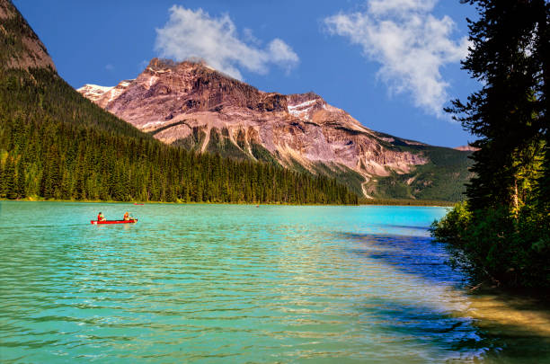 istock emerald green lake, surrounded by coniferous forests and rocky mountains 991609168