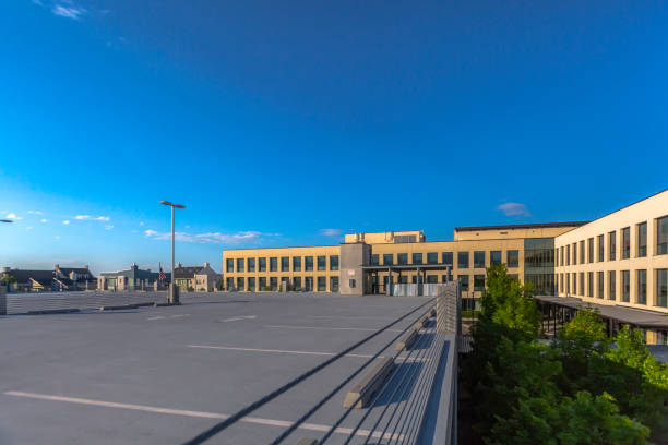 istock Empty parking lot with trees and office building 991653710