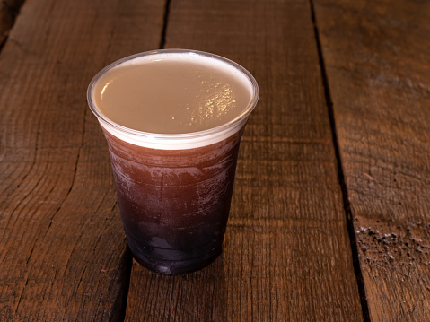 Nitro Cold Brew Coffee beverage on a rustic wood background.
