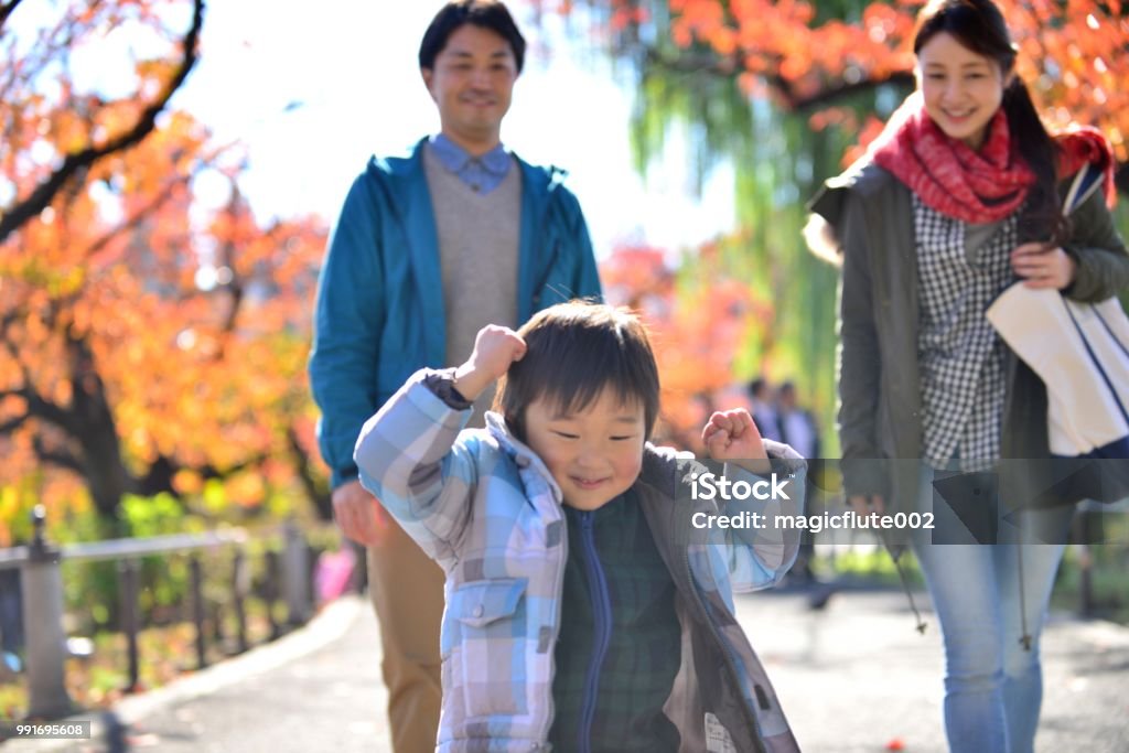 Japanese Couple and Their Son Strolling in Ueno Park, Tokyo Japanese couple in their 30's and their four year old son are strolling hand in hand in Ueno Park, Tokyo, on a fine autumn day. 30-34 Years Stock Photo