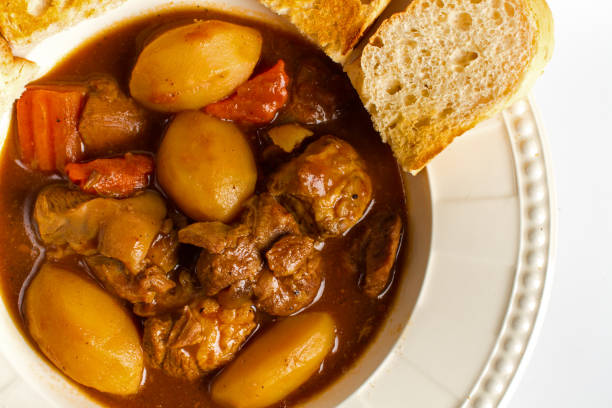 istock Lamb stew with potatoes, carrots, serve with sweet bread on white background 991703228