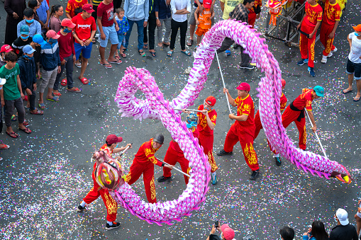 Binh Duong, Vietnam - March 2nd, 2018: Dragon dance festival on the street with martial arts dragon winding control Practitioners of the Chinese Lantern Festival in Binh Duong, Vietnam