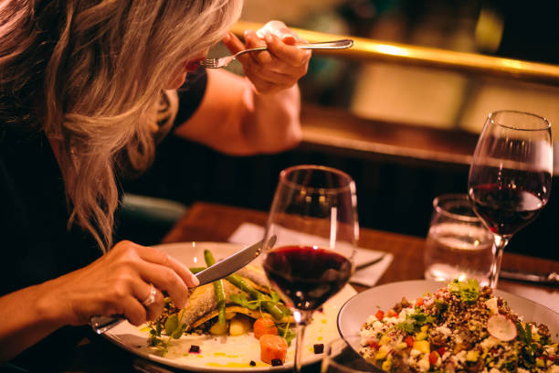 närbild av mogen kvinna hälsosam middag på lyxig restaurang - mature woman having fish bildbanksfoton och bilder
