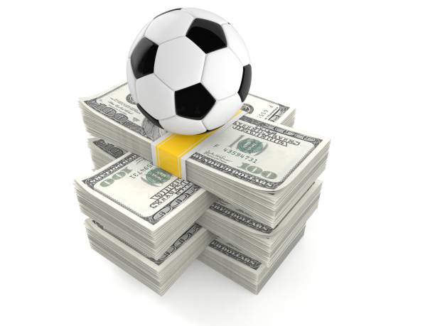istock Soccer ball on stack of money 991754986