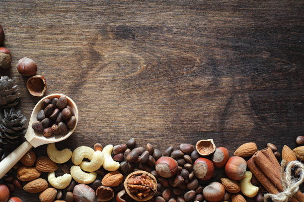 istock Different nuts on a wooden table. Cedar, cashew, hazelnut, walnu 991798810