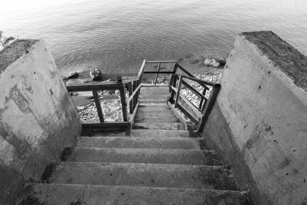 A black and white of the pier bridge at Maraetai beach in Auckland New Zealand.  With the sea and sky.