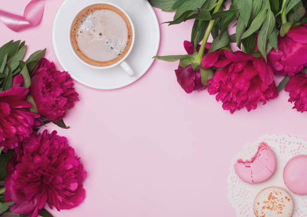 istock Peonies, coffee and macarons on the pink background 991815862