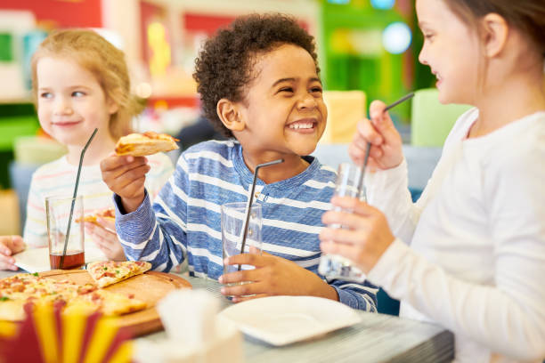 niños felices en pizzería - pizza party fotografías e imágenes de stock