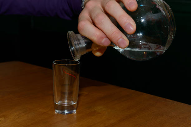 istock hand with a decanter pours vodka into a glass 991820376