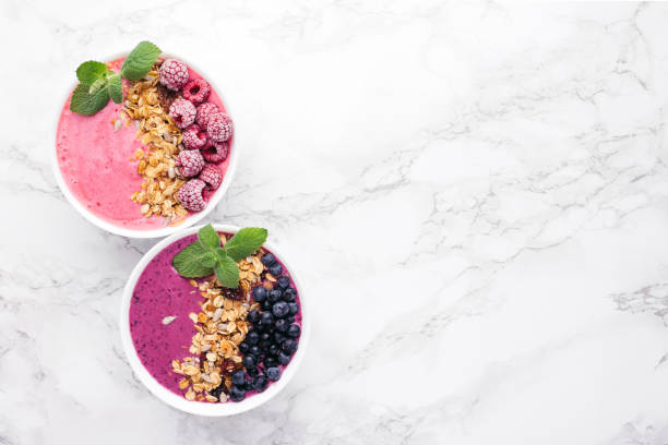 istock Two smoothie bowls with granola and berries. 991828970