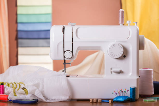 istock Sewing machine and fabric in work, near sewing accessories 991838116