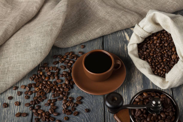 istock Lots of coffee beans, Cup with drink, hand mill, on gray background 991839076