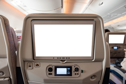 White display screen with joystick on rear seat in passenger plane