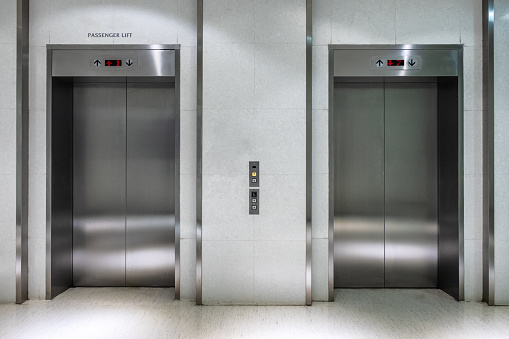 Metallic elevator two gate closed of passenger lift at lobby