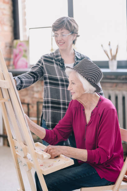 istock Cheerful Senior Woman in Art Class 991857942