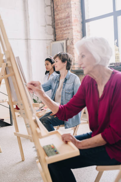 istock Artists Sitting in Row in Art Studio 991857980