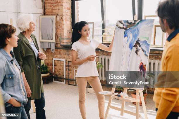 Junge Frau Präsentiert Malerei Stockfoto und mehr Bilder von Kunst - Kunst, Kunstmuseum, Universität