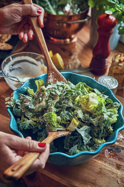 istock Preparing Cesar Salad with Chicken, Lettuce and Parmesan 991861452