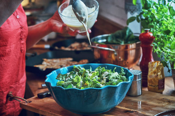 istock Preparing Cesar Salad with Chicken, Lettuce and Parmesan 991861500