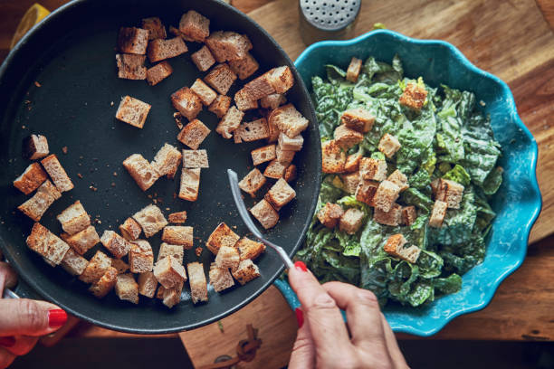 Preparing Cesar Salad with Chicken, Lettuce and Parmesan