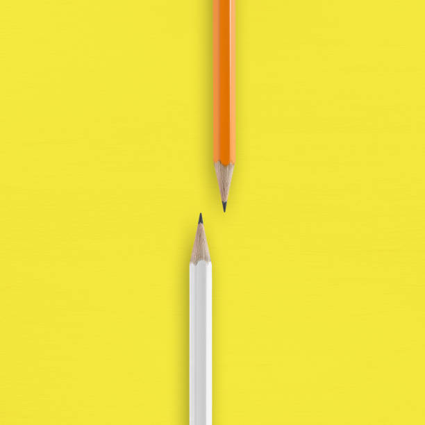 istock White and orange pencils on yellow background 991862576