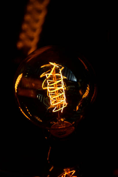 istock Decorative retro styled light bulb shining in the dark 991866890