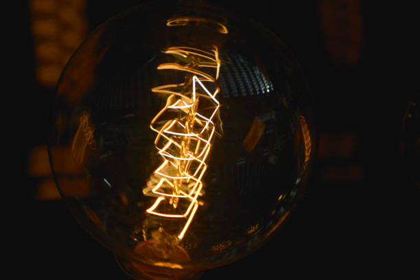 istock Decorative retro styled light bulb shining in the dark 991866906