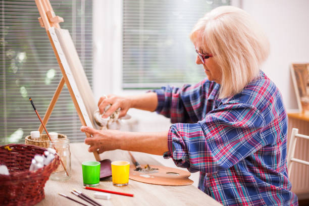 Senior woman art painting Elderly woman is painting in her home. Retirement hobby. painted image paintings oil paint senior women stock pictures, royalty-free photos & images