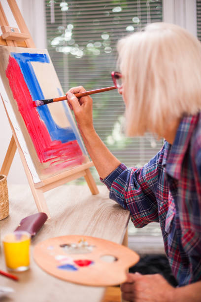 istock Senior woman art painting 991877204