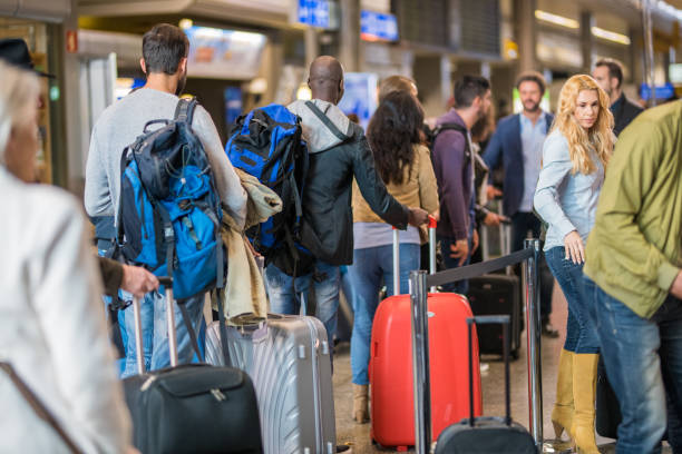 gente de negocios de pie en cola en el aeropuerto - cabello largo fotografías e imágenes de stock