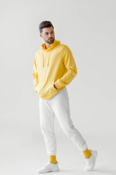istock handsome young man in yellow hoodie posing on white 991877946