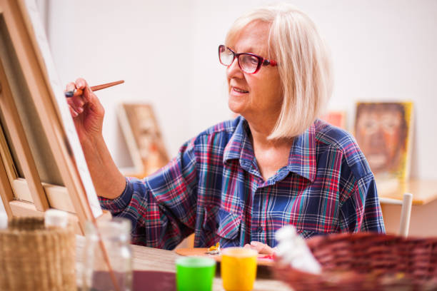 istock Senior woman art painting 991877982