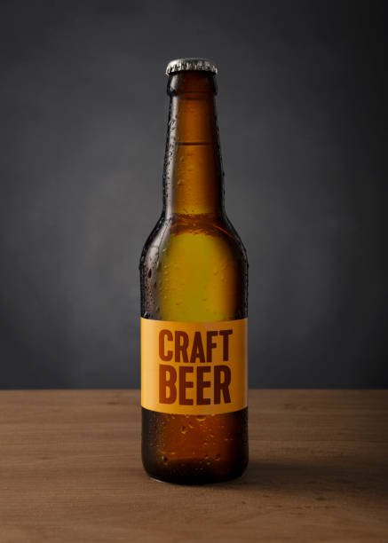 cold craft beer bottle with custom made label on the table against black background beer, bottle, cold, craft craft beer photos stock pictures, royalty-free photos & images
