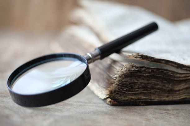 istock Old books on a wooden table and magnifier 991888368