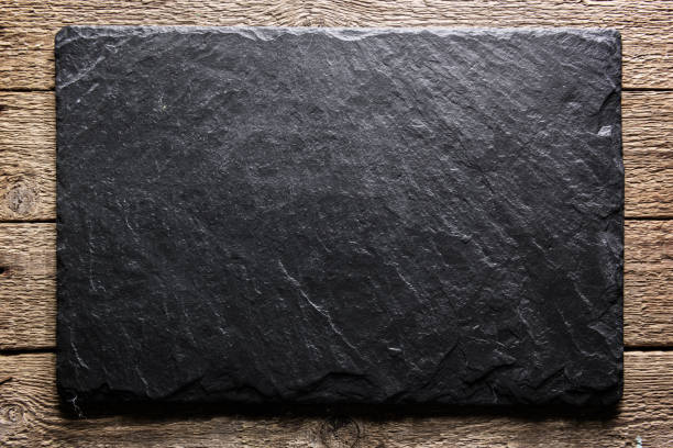 Black slate texture closeup Black slate board on grunge wooden table closeup. Natural texture. Can be used like food background shale stock pictures, royalty-free photos & images