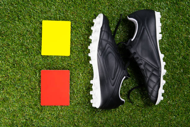 two penalty cards for the referee and soccer shoes, against the background of grass - soccer soccer field grass artificial turf imagens e fotografias de stock