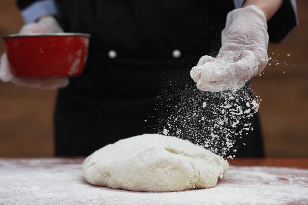 o cozinheiro faz farinha para cozer na mesa - bread kneading making human hand - fotografias e filmes do acervo