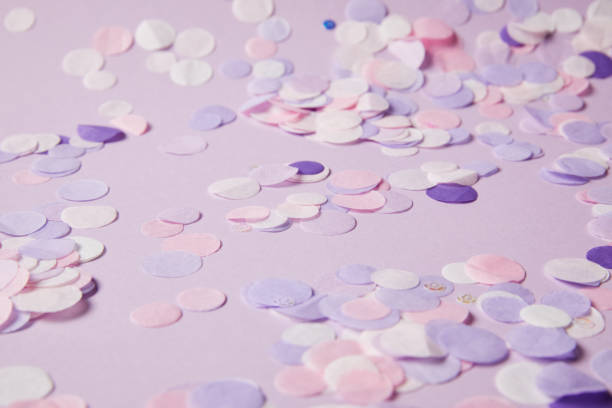 istock selective focus of confetti pieces on violet surface 991899778