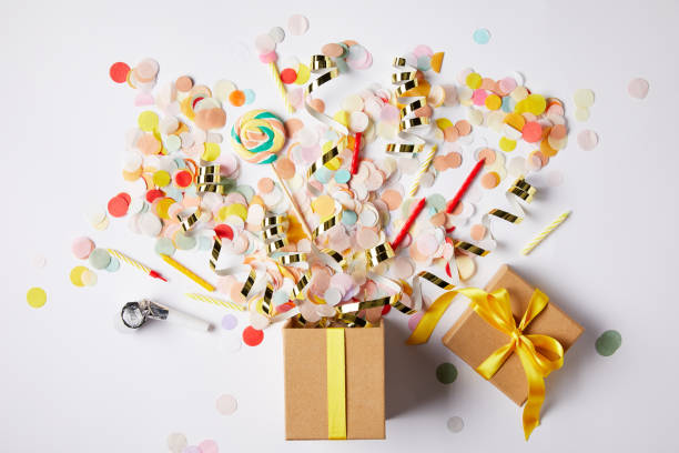 top view of gift box and scattered confetti pieces on white surface top view of gift box and scattered confetti pieces on white surface gift lounge stock pictures, royalty-free photos & images