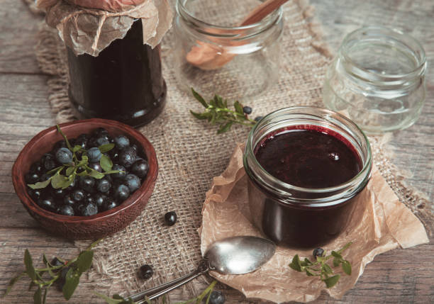 istock Blueberry jam in jar with berries and leaves over rustic wooden table 991903564