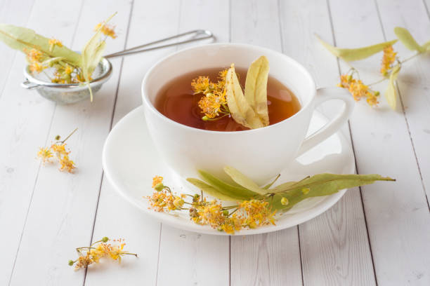 istock Cup of tea with Linden flowers on a light table 991926322