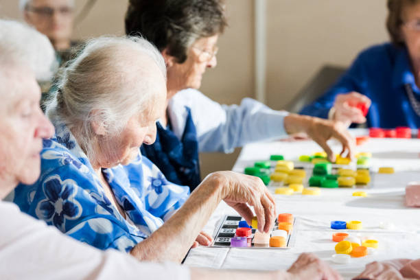 Senior women playing multiple bingo cards Photo of senior woman playing multiple bingo cards in a retirement home free bingo stock pictures, royalty-free photos & images